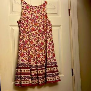 A flowery silhouette, round neck, tiered dress, hits at the knee. Size S